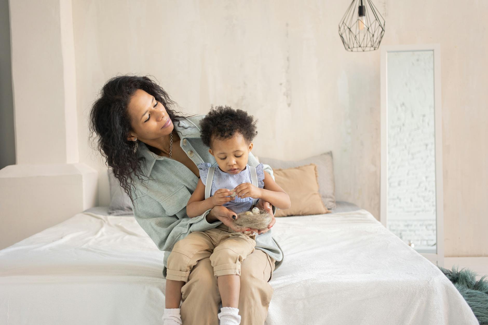 Mama przytula dziecko na łóżku w przytulnej sypialni