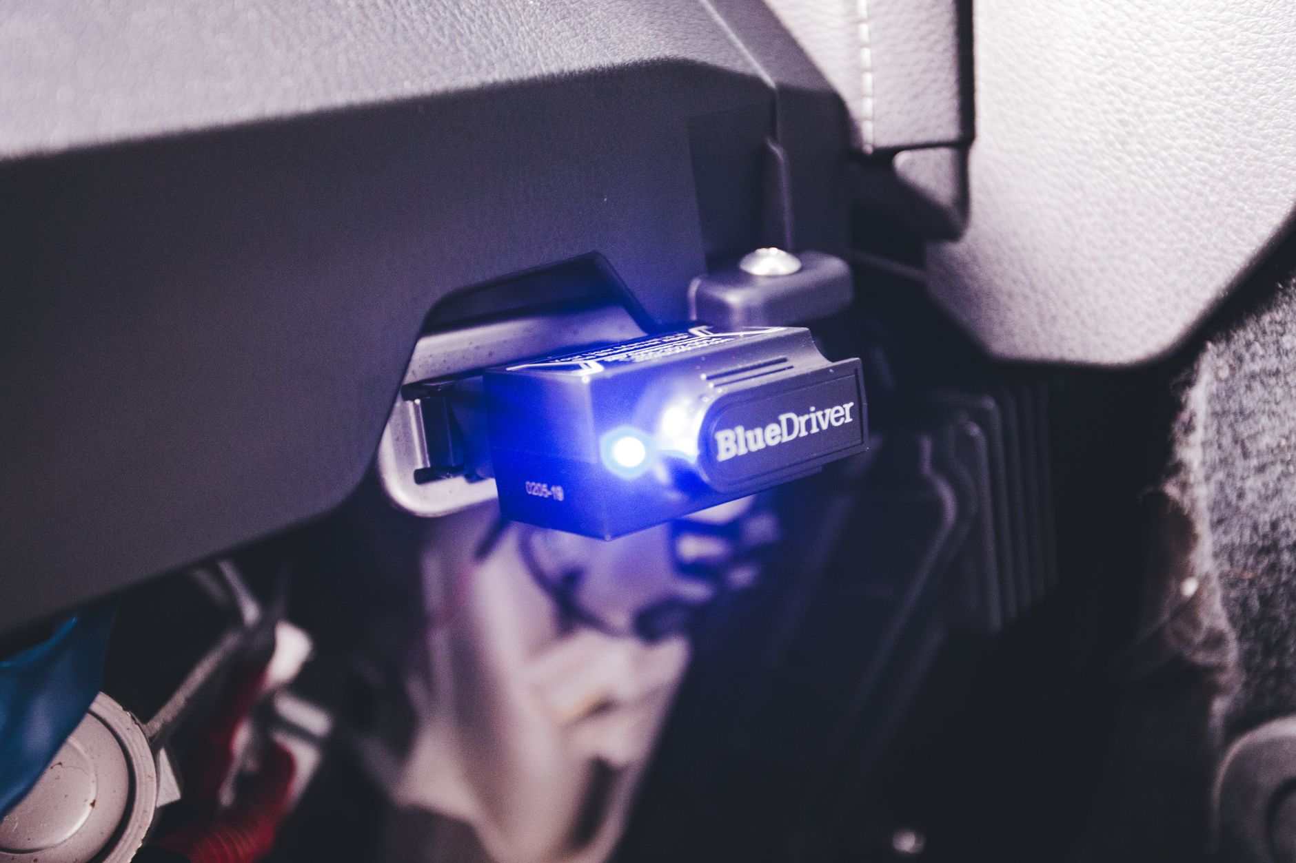 Adapter diagnostyczny BlueDriver OBD2 podłączony wewnątrz auta Mazdy
