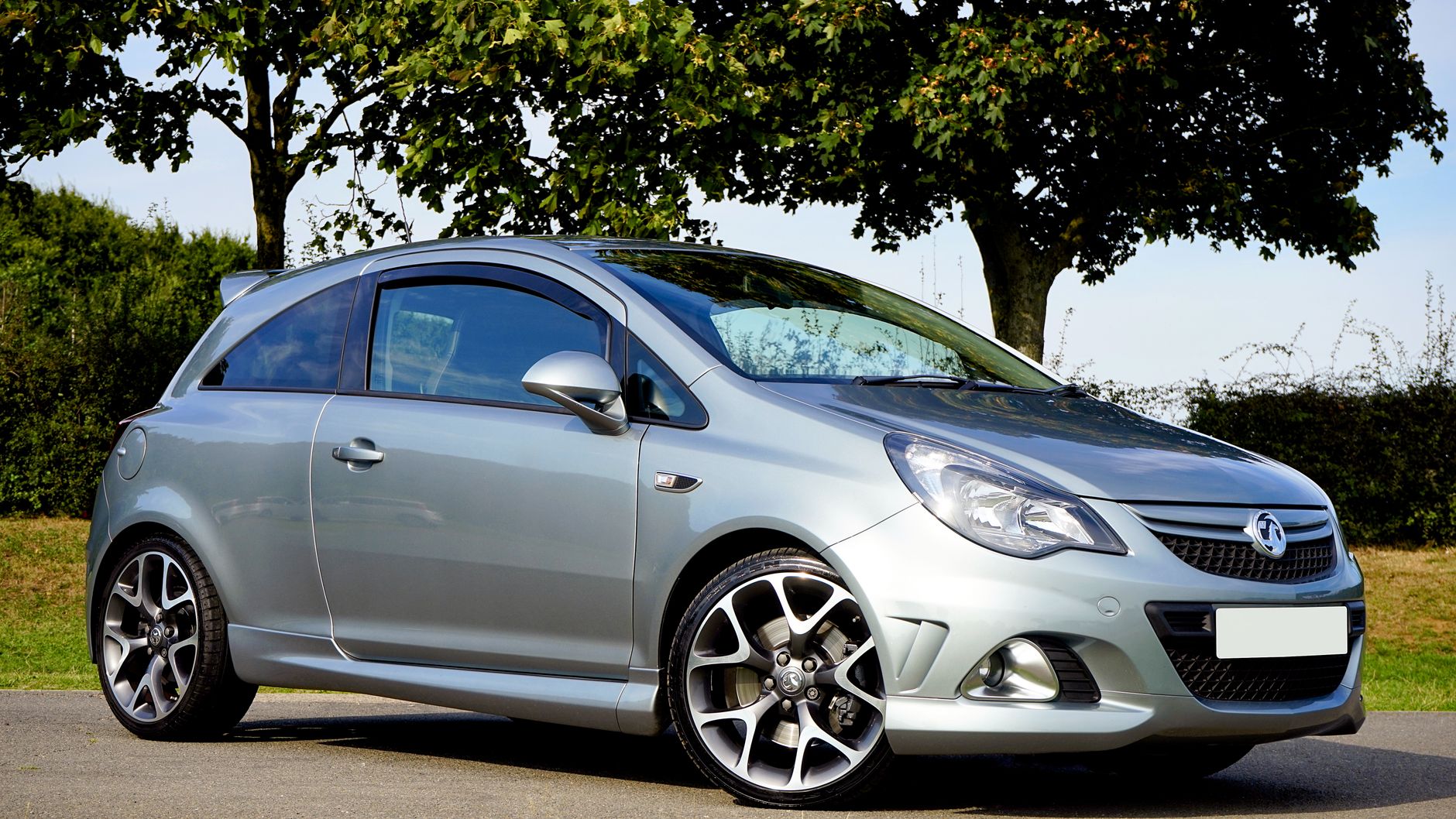 Srebrna Mazda 3 MPS hatchback zaparkowana w słoneczny dzień przy drzewach