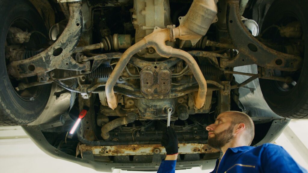 Mechanik ogląda podwozie samochodu w warsztacie